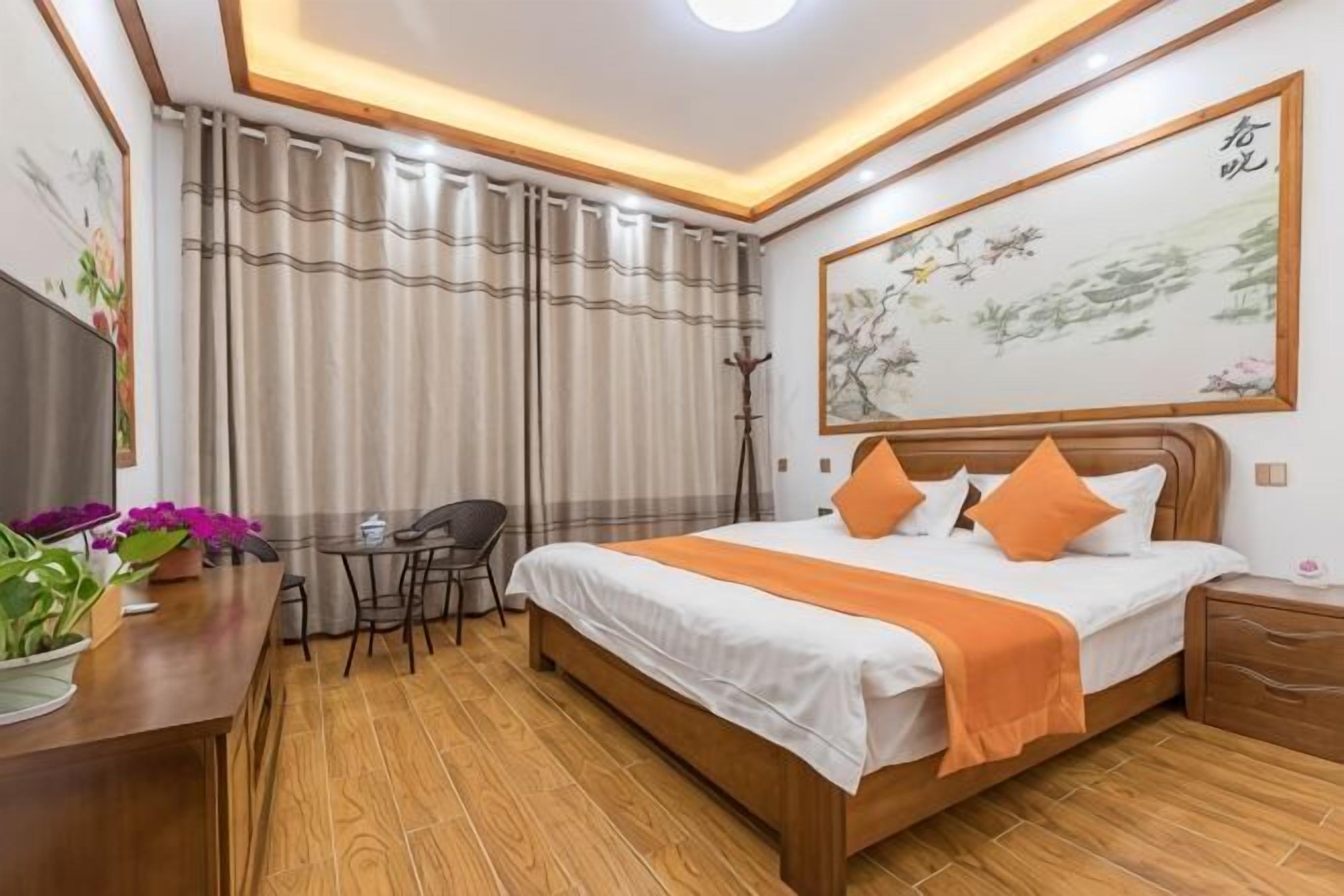 Ein Hotelzimmer mit Bett, Schreibtisch, Stuhl und einem Bild an der Wand.