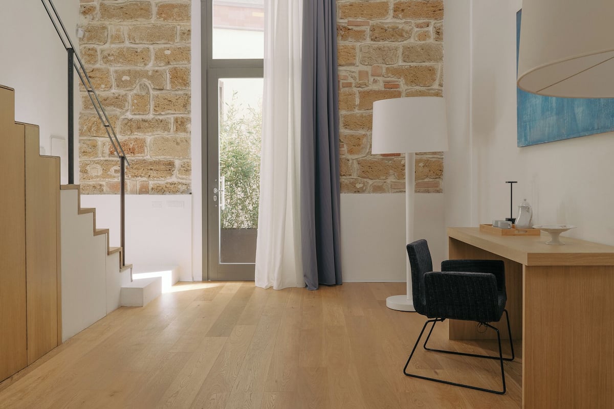 Ein modernes Interieur mit einer Treppe, einem Essbereich und Blick durch eine Glastür.