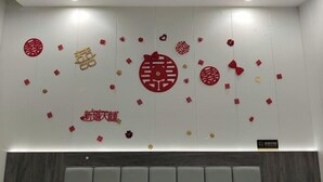 Una pared con elementos decorativos, incluyendo símbolos rojos y dorados, posiblemente de significado cultural.