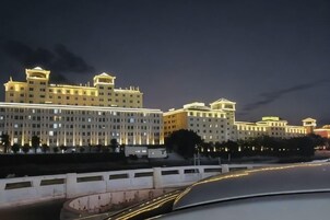 Um hotel com vários andares, fachada simétrica, grandes janelas e telhado plano.