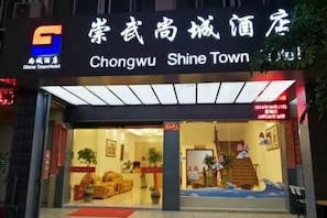 The exterior of Chongwu Shine Town Hotel with a clear entrance and signage.