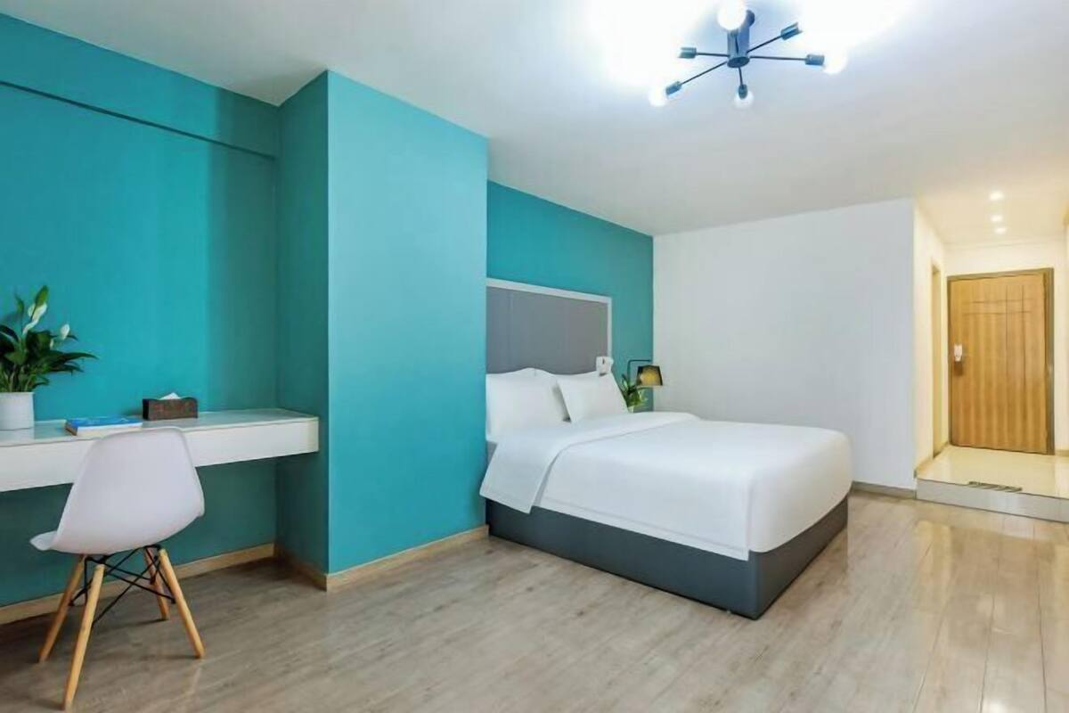 A modern bedroom with a bed, a desk, and a chair.