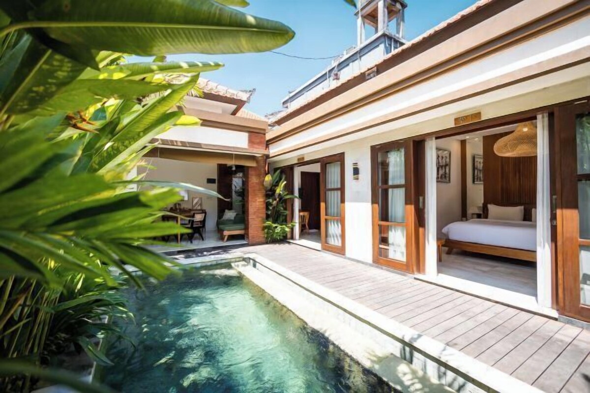 A modern house with a swimming pool, a bedroom with a large bed, and a balcony.