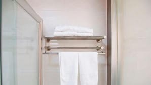 A bathroom with a glass shower enclosure, a towel rack with two folded towels, and a glass door. - Xuancheng Zhongzhou Business Hotel (Xuancheng)