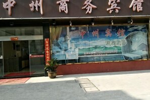 Ein Hotel Eingang mit einem großen Plakat, das das Hotel bewirbt.