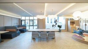 A modern interior with a round table, seating, and pendant lighting.