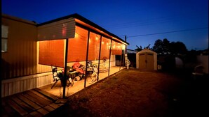 Einbungalow mit überdachter Veranda, Garage und kleinem Garten.