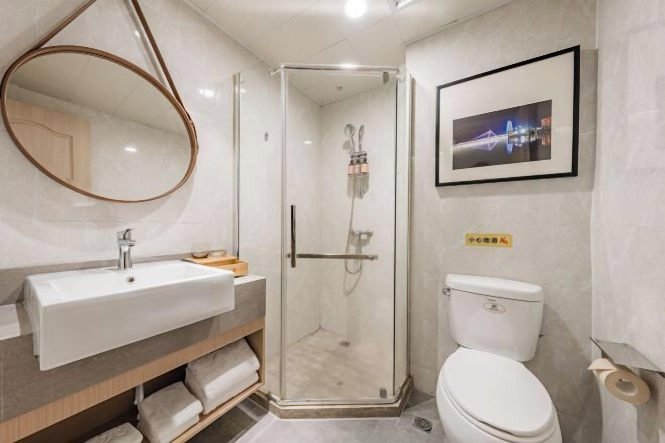 A modern bathroom with a glass-enclosed shower, a sink with a mirror, and a toilet.