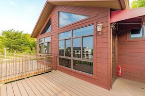 A two-story building with a deck, large windows, and a fire extinguisher. - Shikang Shiwai Taoyuan Leisure Tourist Resort (Guangde)