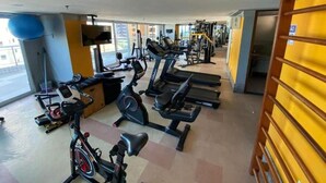 Een sportschool met loopbanden, hometrainers en krachtapparaten.