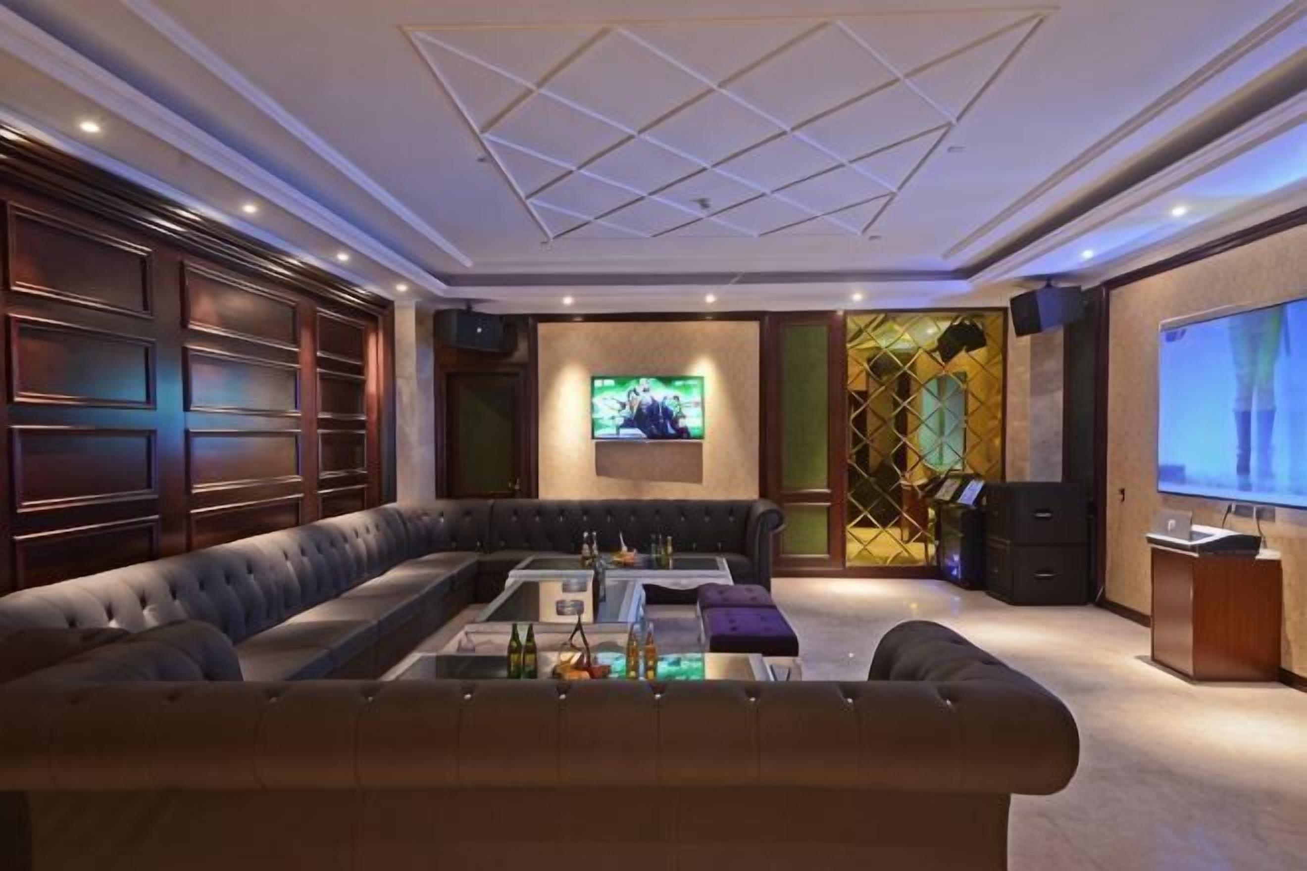 Uma sala de estar moderna com sofá em formato de L, mesa de centro, televisão e lareira.