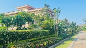 A building with a classical architectural style, surrounded by well-maintained gardens and a paved pathway. - Redbird Hotel Haikou (Haikou)