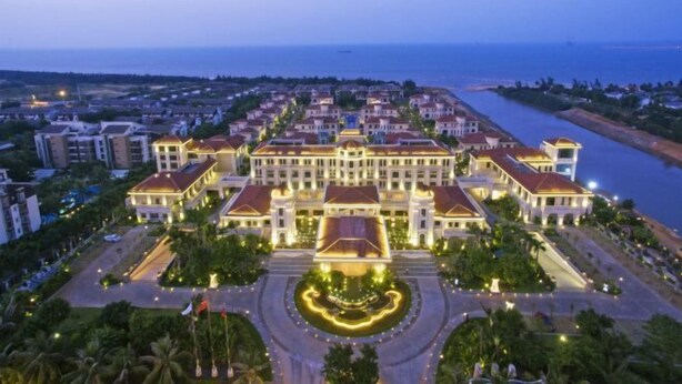 A large, multi-story hotel with a central courtyard and a view of the sea. - Redbird Hotel Haikou (Haikou)
