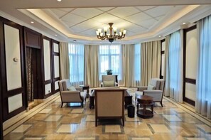 A hotel lobby with a central seating area, large windows, and a chandelier. - Redbird Hotel Haikou (Haikou)