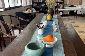 Une table à manger avec des bols, des baguettes et un vase.