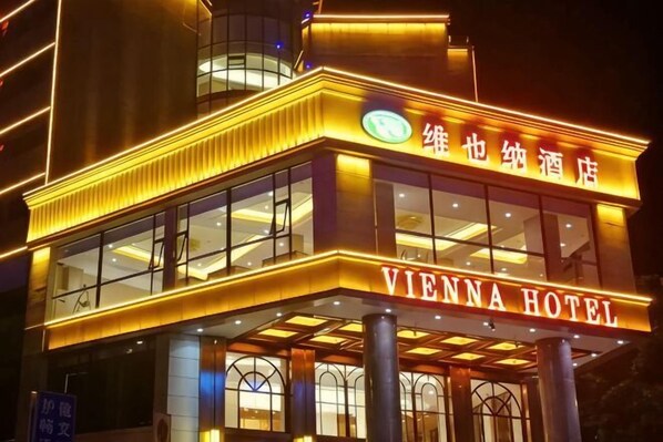 A hotel with a prominent sign reading 'VIENNA HOTEL' and a balcony area.