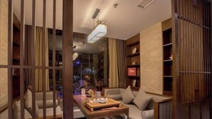 A modern living room with a sofa, a coffee table, and a bookshelf. - Vienna Hotel (Ziyang)