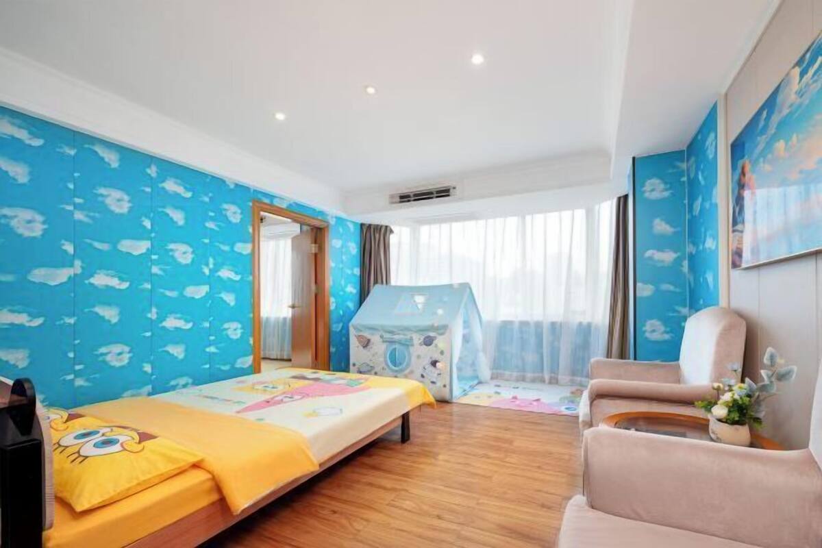 A child's bedroom with a bed, a play tent, a chair, and a window with curtains.