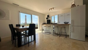 A modern kitchen with a dining area, large windows, and a view of the Eiffel Tower. - House with breathtaking views of the Luberon (Caseneuve)