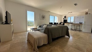 A spacious room with a large bed, a desk, and a kitchenette. - House with breathtaking views of the Luberon (Caseneuve)