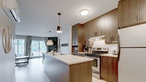 Una cocina moderna con armarios de madera, una isla central y electrodomésticos de acero inoxidable.