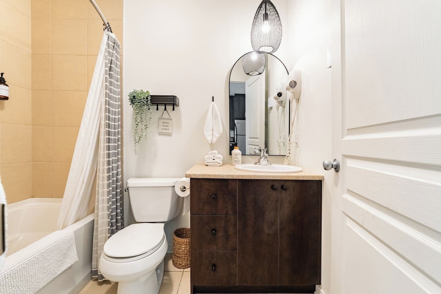 A bathroom with a shower, toilet, sink, and cabinet.
