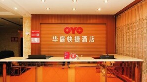 A hotel reception desk with a wooden finish and a large OYO logo. - huating hotel (Zhao County)