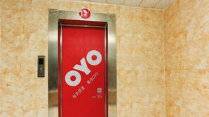 An elevator with a red door and the "OYO" logo, indicating it is part of the OYO hotel chain. - huating hotel (Zhao County)