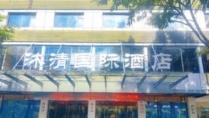 Un hotel con una facciata moderna, ampie vetrate e una segnaletica chiara che indica che si tratta di una struttura internazionale.