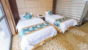 Una habitación de hotel con dos camas, un ventanal grande y una alfombra estampada.