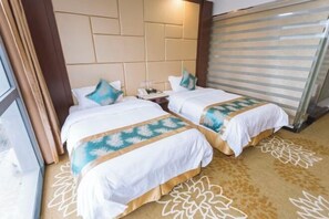 A hotel room with two beds, a large window, and a patterned carpet. - Muqing International Hotel (Guilin)