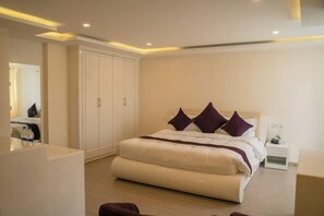 Ein modernes Schlafzimmer mit einem großen Bett, einem Kleiderschrank und einem Nachttisch.