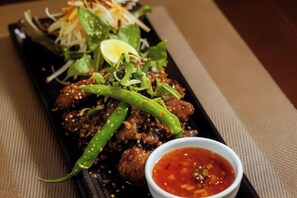 A dish with meatballs, green chili, and a side of sauce. - Hotel Black Diamond (Kathmandu)