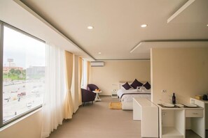 Ein Hotelzimmer mit Bett, Nachttisch und Schreibtisch mit Stühlen.