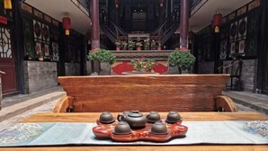 Ett traditionellt teservis på ett träbord i ett rum med utsmyckade väggar och ett altare i mitten.