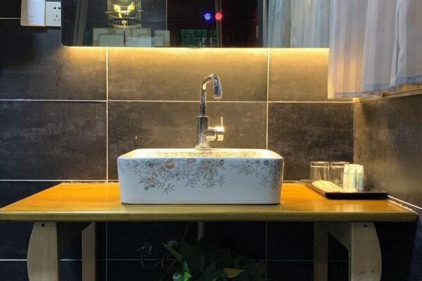 A bathroom with a rectangular sink, a mirror, and a wooden countertop. - PingYao DeShengLou Hotel (Pingyao County)