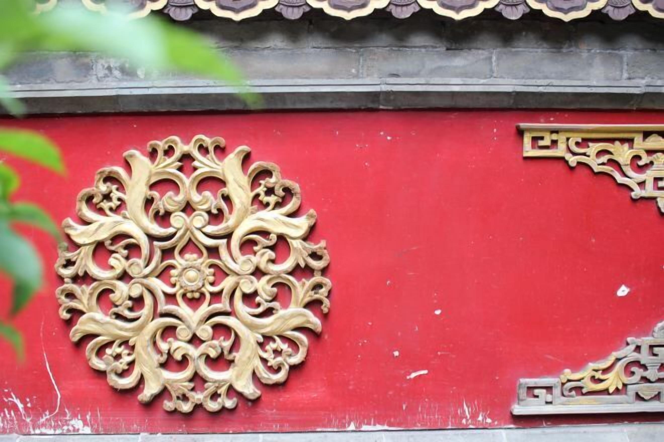 A red wall with ornate gold metalwork.