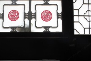 A window with two square panes, each containing a red circular design. - PingYao DeShengLou Hotel (Pingyao County)