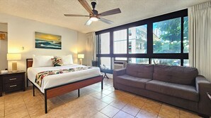 A hotel room with a bed, a sofa, a ceiling fan, a large window with a view of buildings, and a painting on the wall. - Charming studio in wonderful Honolulu w/ WiFi & AC-Sleeps 3
WAIKIKI GRAND HOTEL® (Honolulu)