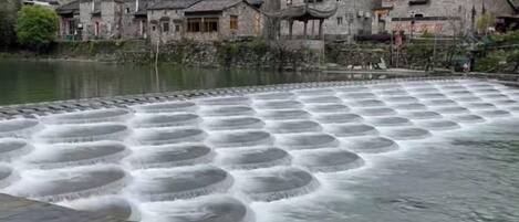 A traditional building with a water feature in front.