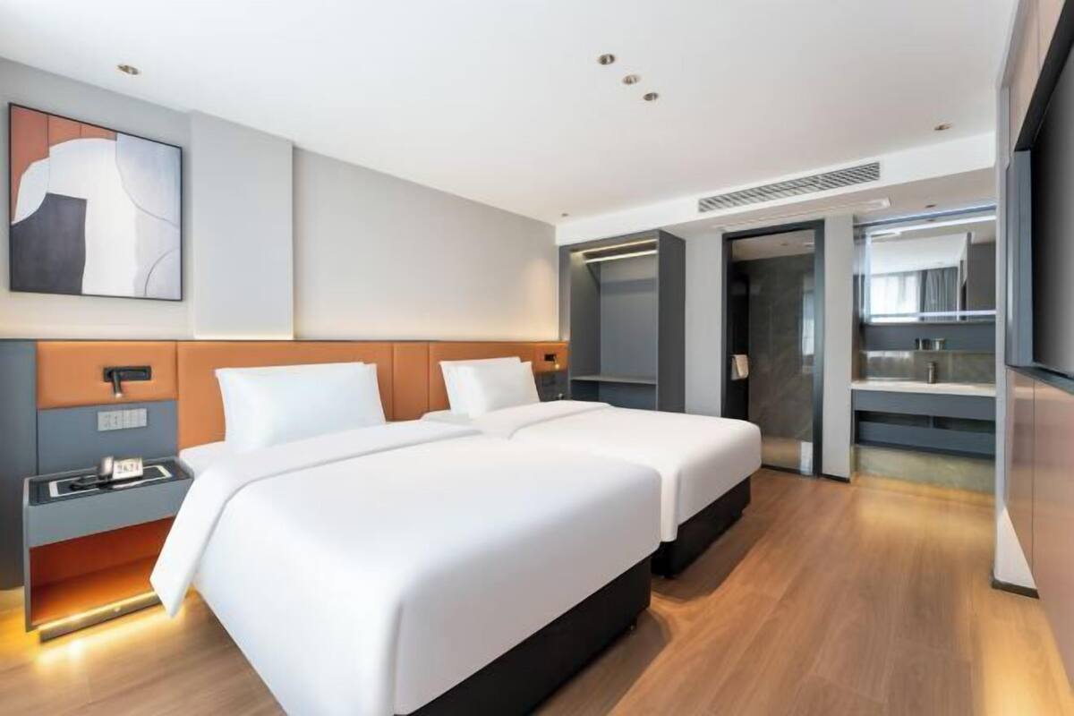 Una habitación de hotel moderna con una cama grande, una mesita de noche y un armario empotrado.