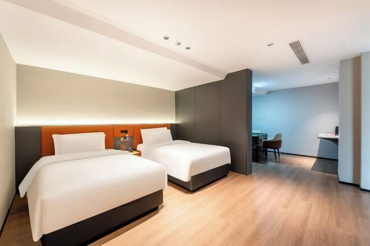 Una habitación de hotel moderna con dos camas, un escritorio y una silla.