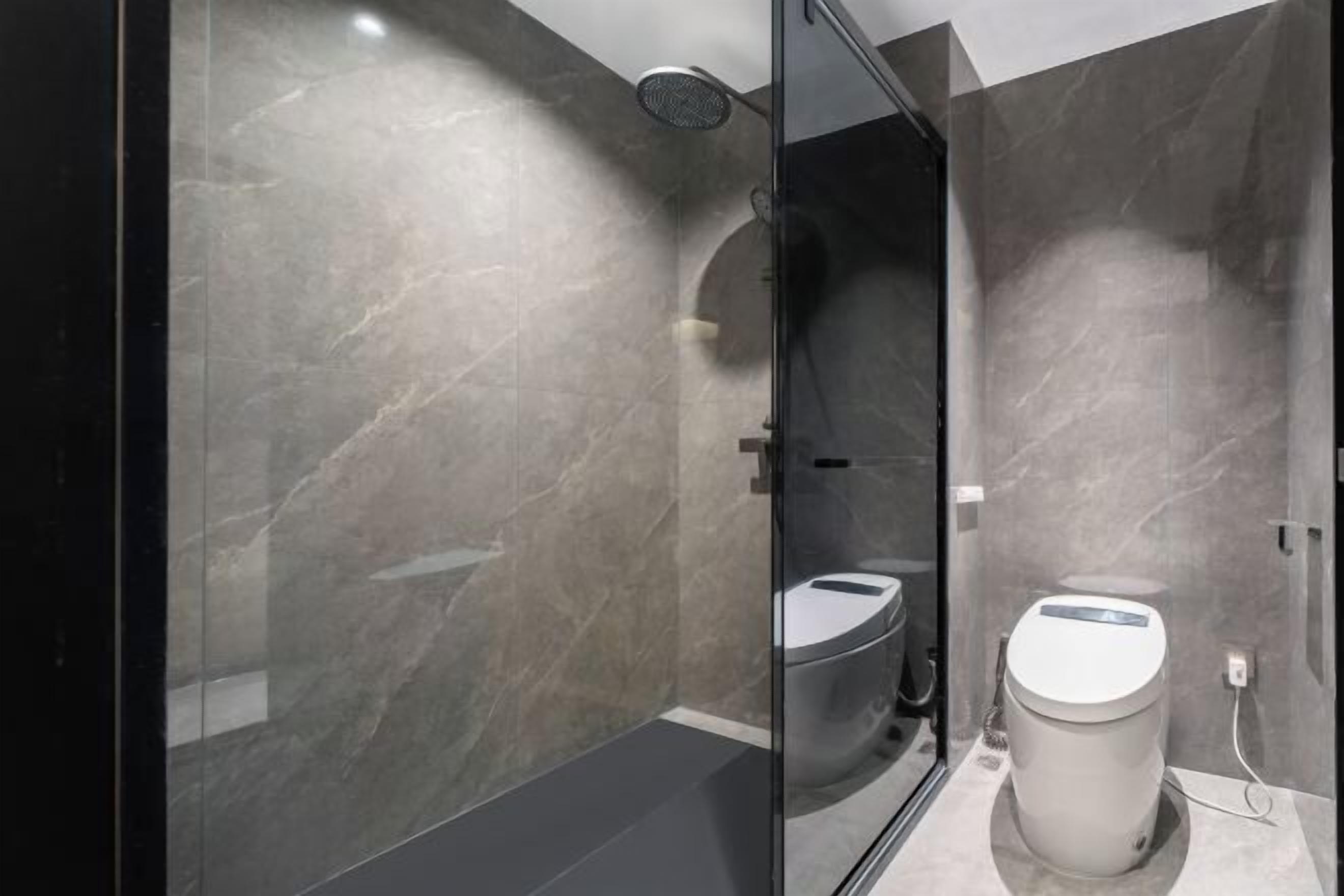 A modern bathroom with a glass-enclosed shower, a toilet, and a bidet.
