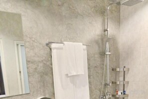 A bathroom with a shower, a towel rack, and a mirror.