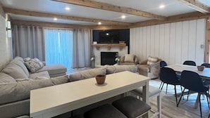 Un salon moderne avec un canapé, une table à manger et des chaises.