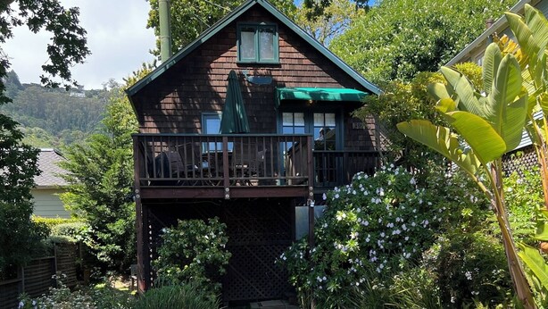 A two-story wooden house with a balcony, surrounded by a garden with various plants and a gravel path. - Cozy quiet & relaxing hide-a-way in the heart of Sausalito's ‘Hurricane Gulch.’ (Sausalito)