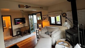 A cozy living room with striped sofas, a fireplace, and a television. - Cozy quiet & relaxing hide-a-way in the heart of Sausalito's ‘Hurricane Gulch.’ (Sausalito)