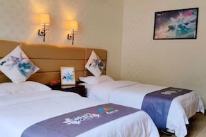 Ein Hotelzimmer mit zwei Betten, einem Kopfteil, Wandlampen, einem gerahmten Bild und einem Gemälde.