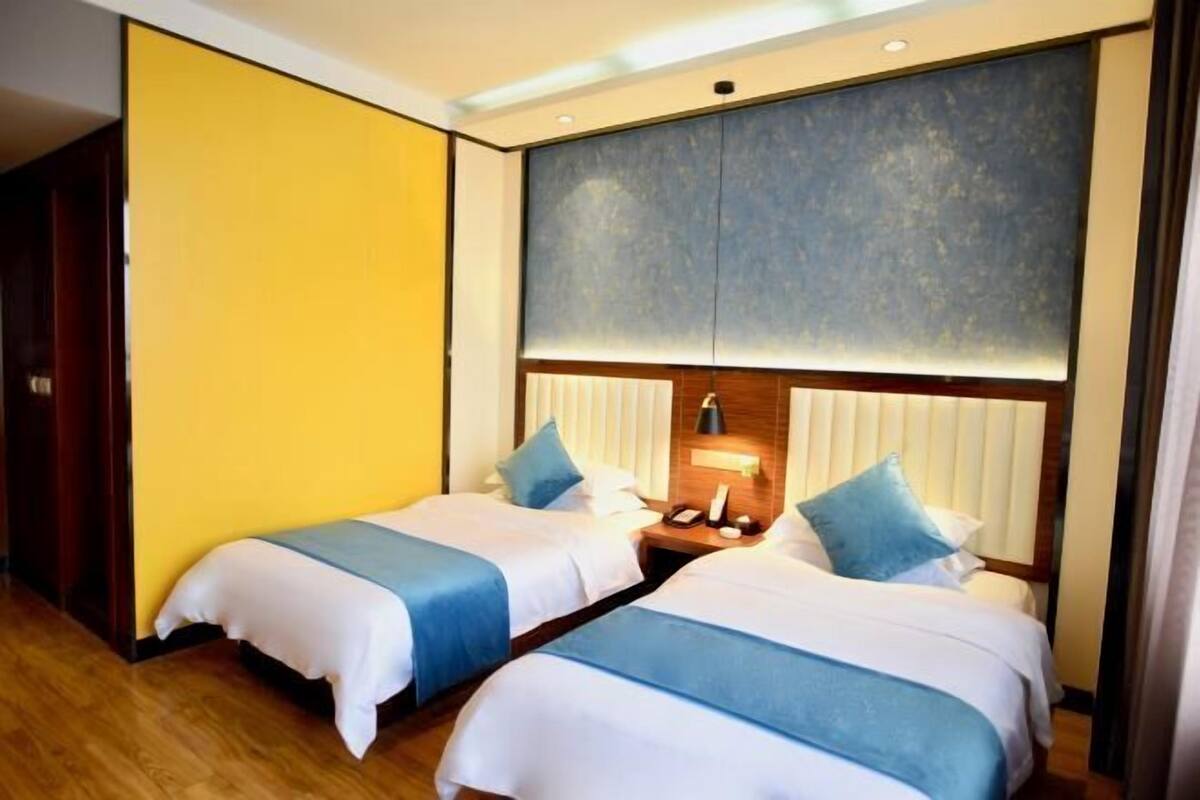 Une chambre d’hôtel avec deux lits, un plancher en bois et un grand panneau mural.