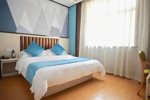 Une chambre d’hôtel avec un lit, une table de chevet, une chaise et une fenêtre avec des rideaux.
